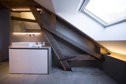 an attic bathroom with a sink and a window at Etoile de Pompadour in Arnac-Pompadour