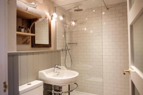 a white bathroom with a sink and a mirror at The White Hart in Stockbridge
