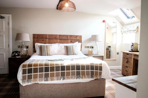 a bedroom with a large bed and a mirror at The White Hart in Stockbridge