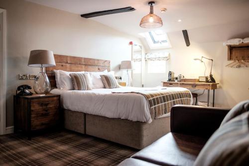 a bedroom with a large bed and a lamp at The White Hart in Stockbridge
