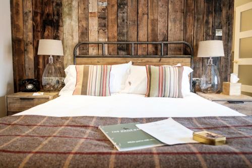 a bedroom with a bed with a book on it at The White Hart in Stockbridge