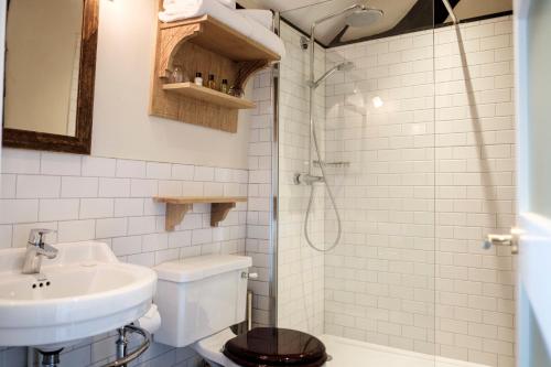 a bathroom with a sink and a toilet and a shower at The White Hart in Stockbridge