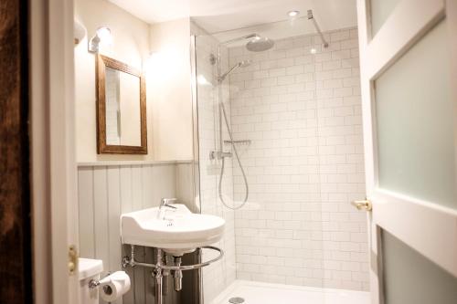 a white bathroom with a sink and a shower at The White Hart in Stockbridge