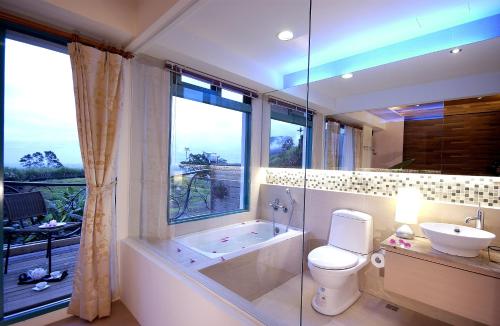 a bathroom with a tub and a toilet and a sink at Ying Yue Villa in Datong