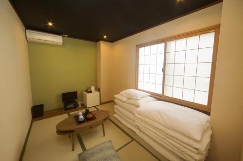 a room with a couch and a table and a window at Seiki Kyoto Station in Kyoto