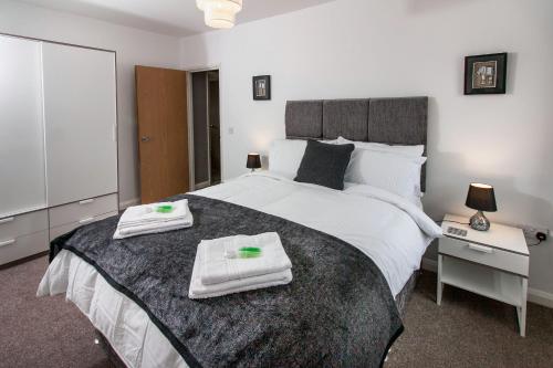 1 dormitorio con 1 cama grande y toallas. en Cwrt Sofia, en Cardiff