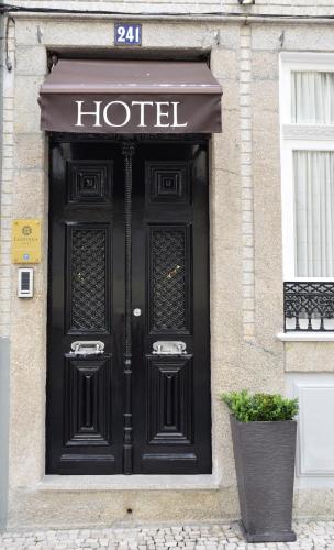 a large black door to a hotel on a building at Lusitana Hotel in Porto