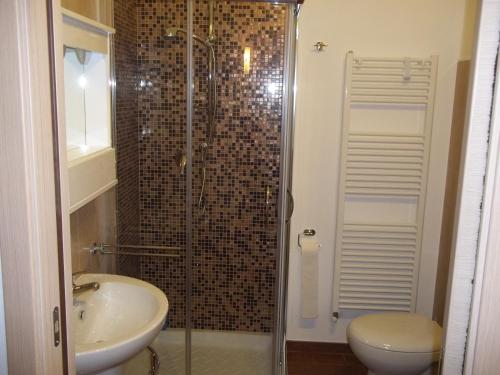 een badkamer met een douche, een wastafel en een toilet bij beb Il vicoletto in Troia