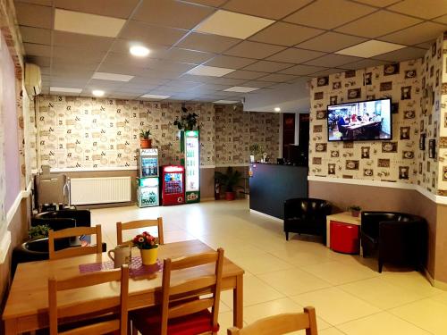 een restaurant met een tafel en stoelen en een tv bij Hotel Mic in Boekarest