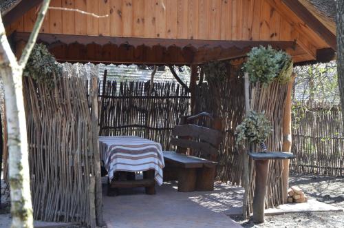 a wooden gazebo with a table and a bench at Chumatskiy Shlyah in Romankiv
