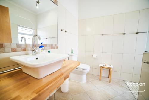 a white bathroom with a sink and a toilet at Meike's Guesthouse in Swakopmund