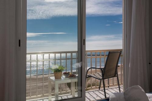 a view of a balcony with a table and a chair at SingularStays El Faro in Puzol