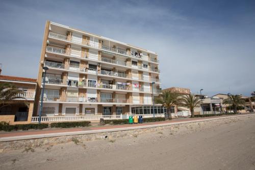 a large apartment building on the beach with a street at SingularStays El Faro in Puzol