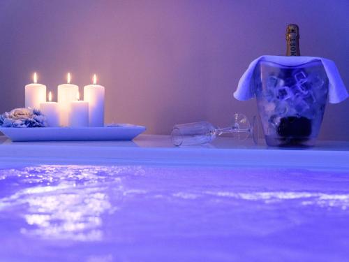a table with candles and a bottle and a glass at Bellariva Monopoli B&B e Relax in Monopoli
