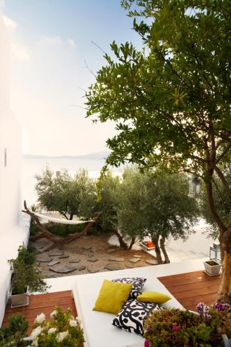 a white couch with pillows on a deck with a tree at Casa Aiora in Adamas