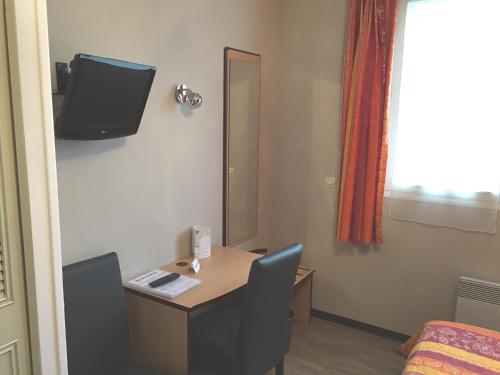 a room with a table and a mirror and a bed at Hotel du Haut Marais in Saint-Marcel