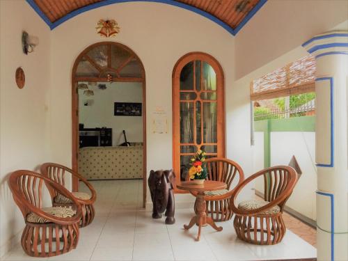 a dog sitting in a room with a table and chairs at Romeo and Juliet Guest House in Negombo