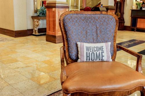 a wooden chair with a welcome home pillow on it at Hotel Providence in Providence