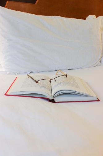 an open book on a bed with glasses on it at Hotel Providence in Providence