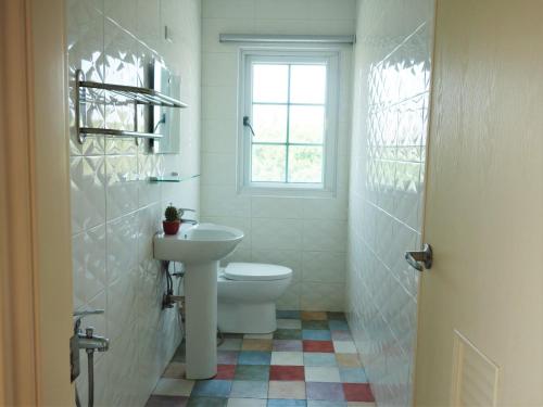a bathroom with a toilet and a sink and a window at Wind Island in Magong