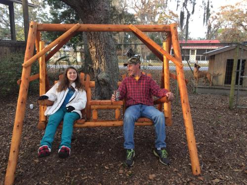 a man and a woman sitting in a swing at Steinhatchee River Inn and Marina in Steinhatchee