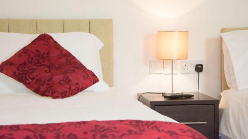 a hotel room with a red pillow on a bed at Walsh's Bridge Inn in Newport