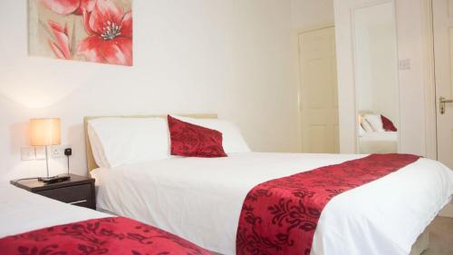 a hotel room with two beds with red pillows at Walsh's Bridge Inn in Newport