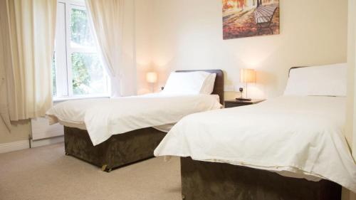 2 camas individuales en una habitación con ventana en Walsh's Bridge Inn, en Newport