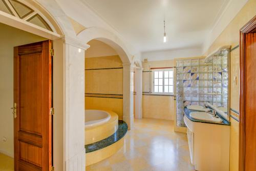 a bathroom with a tub and a sink at Villa Menir in Lagoa