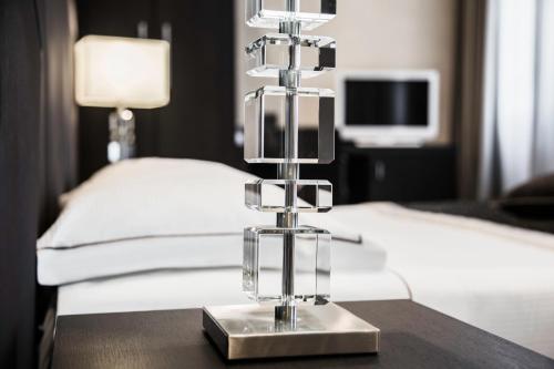 a silver object on a table next to a bed at Hotel Principe Di Torino in Turin