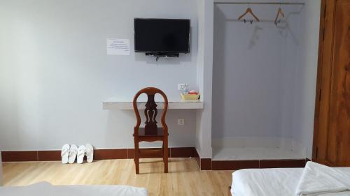 a room with a chair and a tv on a wall at KampongBay Makeng II Guesthouse in Kampot
