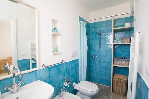 un bagno piastrellato blu con un water e un lavandino di Villa Le Terrazze plus Pool a Gagliano del Capo