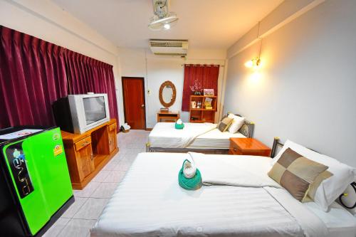 a hotel room with two beds and a tv at Saithong House in Chiang Mai