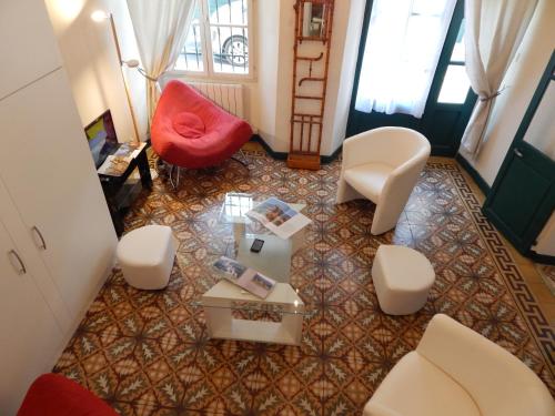 een woonkamer met een rode stoel en een tafel bij la clef du couvent in Vaison-la-Romaine