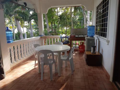 einen Tisch und Stühle auf einem Balkon mit einem Tisch und einem Fenster in der Unterkunft Villa Juana in Panglao