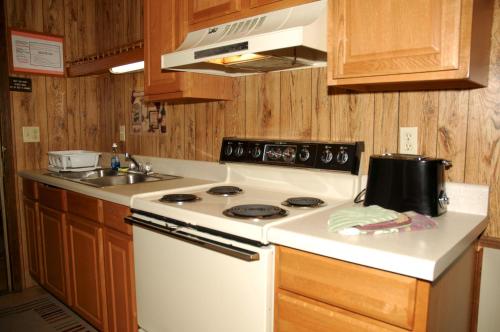 a kitchen with a white stove and a sink at Carolina Landing Camping Resort Cabin 10 in Fair Play