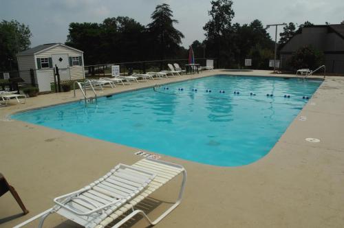 a large swimming pool with a white lounge chair in it at Carolina Landing Camping Resort Cabin 10 in Fair Play