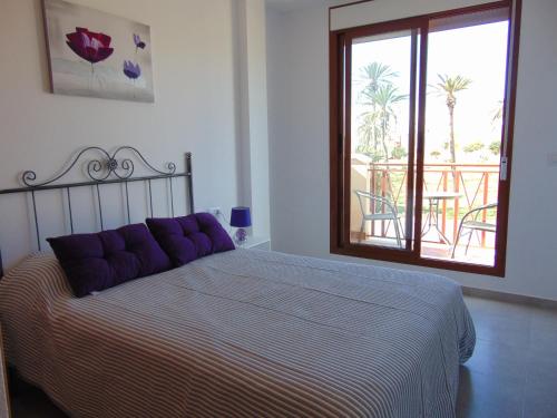 プエルト・デ・マサロンにあるDuplex 5 Mar de Plataのベッドルーム(紫色の枕が付くベッド1台、バルコニー付)