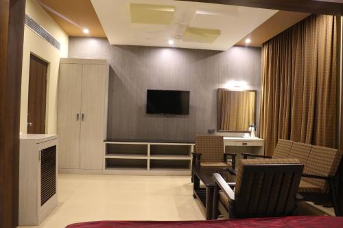 Una sala de estar con un televisor en la pared. en DsrMadhanamInn, en Kumbakonam