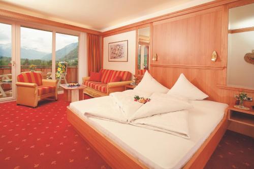 ein Hotelzimmer mit einem Bett und einem Balkon in der Unterkunft Panorama Hotel Nocturnes in Naturns
