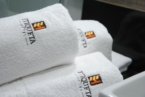a pile of white towels sitting on a table at Etiqueta Hotel in Santa Cruz do Capibaribe