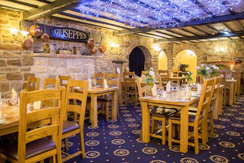 a dining room with wooden tables and chairs at Santo's Higham Farm Hotel in Alfreton