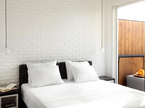 a white bedroom with a large bed with white pillows at Athens View Loft - 02 in Athens
