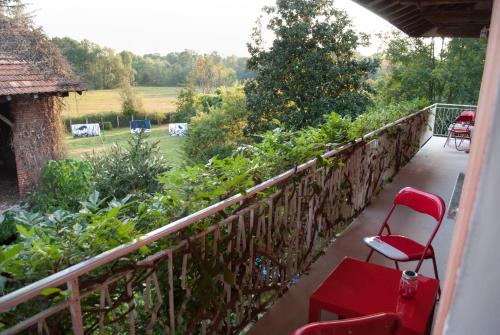 a balcony with a red chair and a garden at Otium B&B in Cavallirio