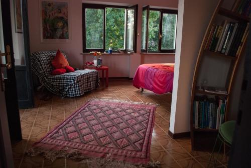 Habitación con cama, silla y ventanas. en Otium B&B en Cavallirio