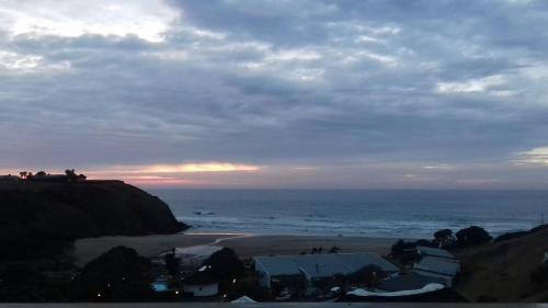 a view of a beach and the ocean at sunset at Uberkei in Coffee Bay