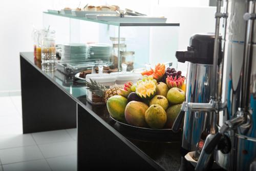 a buffet line with a bowl of fruit on a counter at Etiqueta Hotel in Santa Cruz do Capibaribe