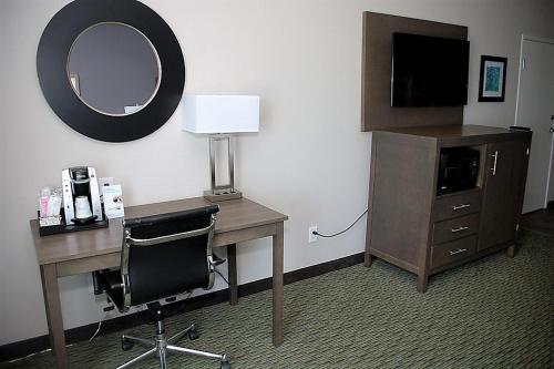 a hotel room with a desk and a mirror at Holiday Inn Express Hotel and Suites Port Aransas/Beach Area by IHG in Port Aransas