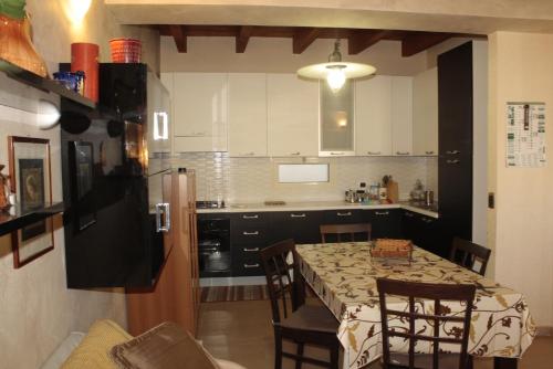 a kitchen with a table with chairs and a refrigerator at Casa-B&B Bouganville Attico 85 mq in Barletta