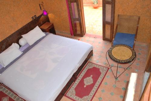 a bedroom with a bed and a table and a chair at Gite Souss in Oulad Teima